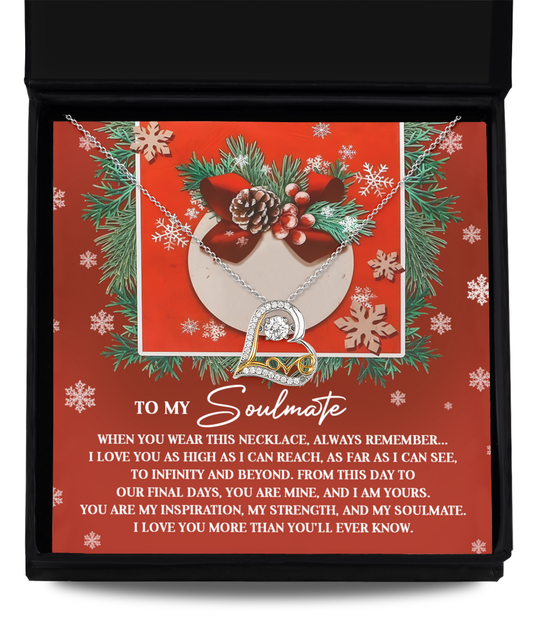 The Soulmate-I Am Yours - Love Dancing Necklace, featuring intertwined hearts and crystals set in exquisite 14k Gold, is beautifully displayed in a box against a red holiday-themed backdrop, paired with a heartfelt message to a soulmate.