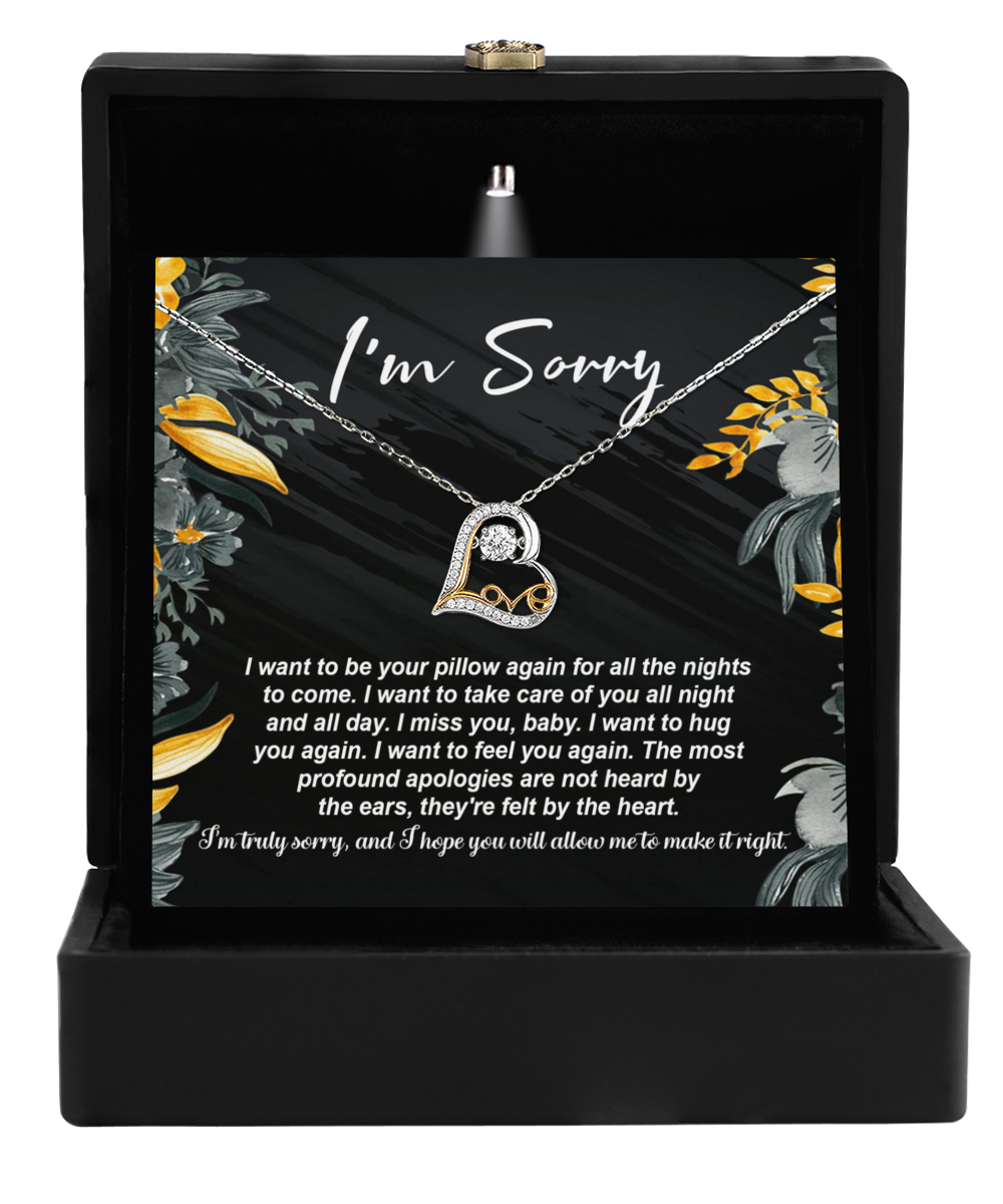 The Sorry-Be Your Pillow - Love Dancing Necklace is crafted from 14k gold, nestled in a black box with floral designs. A heart-shaped pendant and the message "I'm Sorry" capture the essence of maternal love.