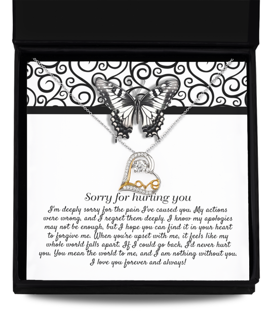 The Sorry-Nothing Without You - Love Dancing Necklace is a .925 sterling silver piece featuring a pendant of interlocking hearts. It is beautifully displayed on a card adorned with an apology message and a butterfly graphic, all elegantly packaged in a black box. The text on the card conveys regret and love.