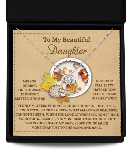 A jewelry box featuring the "Daughter-On The Wall - Love Dancing Necklace," a sterling silver piece adorned with a circular pendant. Surrounded by autumn-inspired decorations, it includes a heartfelt message to a daughter that expresses inner beauty and love, elegantly highlighted with sparkling cubic zirconia accents.