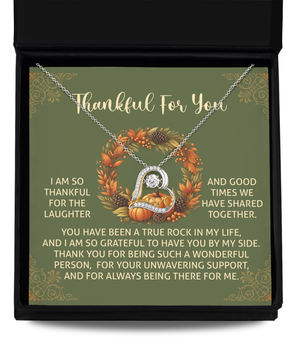 The Thanksgiving-By My Side - Love Dancing Necklace, featuring a heart-shaped pendant crafted from sterling silver, rests on a note of gratitude and appreciation, adorned with autumn-themed decorations.