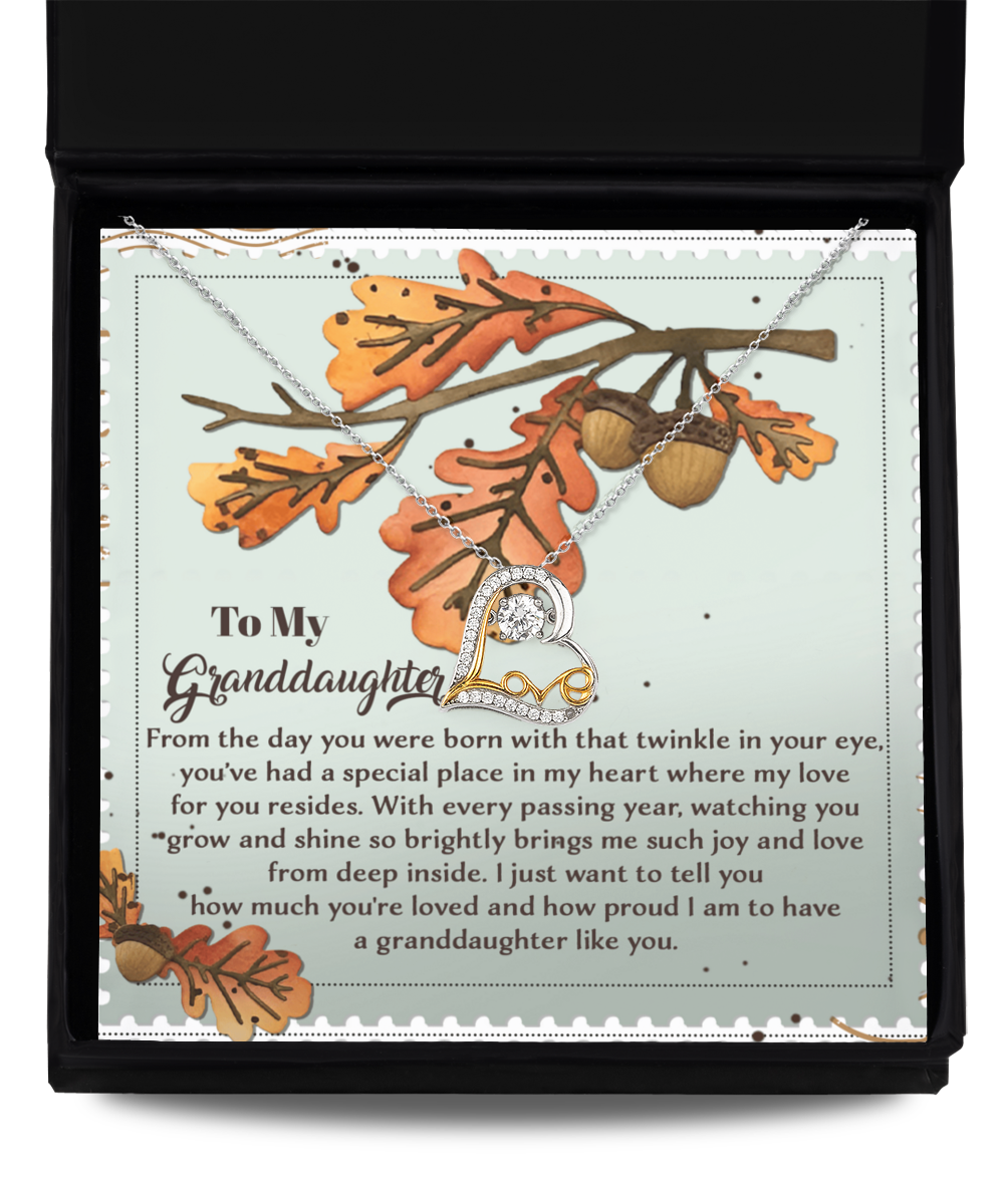 Presented in a charming box, the Granddaughter-From Deep Inside - Love Dancing Necklace, crafted from sterling silver, rests against a backdrop of autumn leaves and acorns, conveying a heartfelt message to your granddaughter.