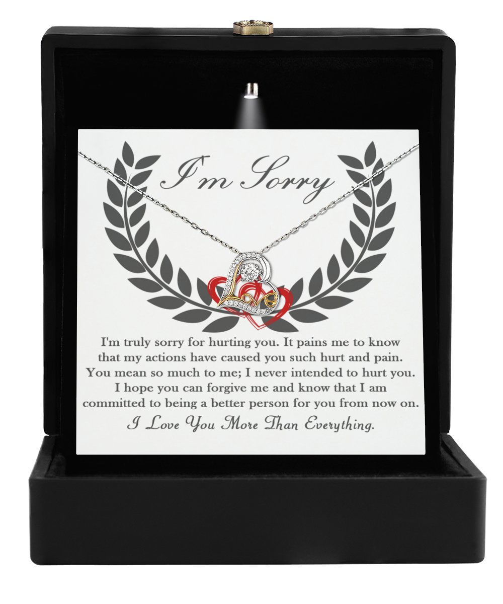 Open black jewelry box displaying the "Sorry-From Now On - Love Dancing Necklace," featuring intertwined hearts and a message of apology and love.