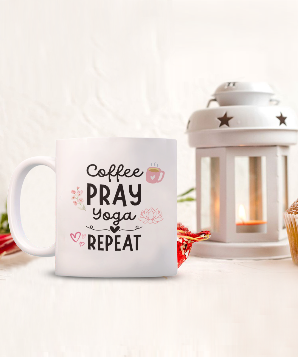 The Coffee Pray Yoga Repeat mug features a cup design with "Coffee Pray Yoga Repeat," a pink heart, and a lotus flower. The background includes a lit lantern and cupcake. It's the perfect addition to your calming rituals—don't miss this LIMITED TIME offer!.