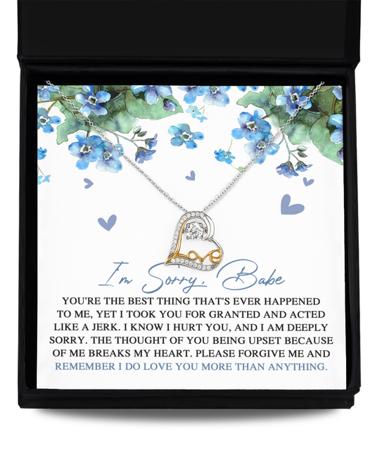 The "Sorry-More Than Anything- Love Dancing Necklace," a .925 sterling silver piece featuring an intertwined heart pendant, is elegantly presented in a black box alongside a note adorned with blue floral decorations. The note conveys an apology for taking someone for granted and expresses profound love and remorse.