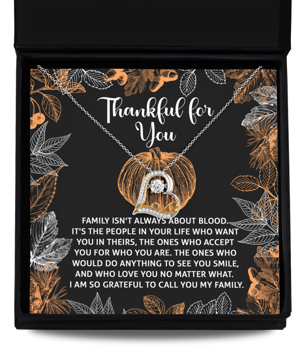 The Thanksgiving-To Call You - Love Dancing Necklace, crafted in sterling silver, showcases a heart pendant presented inside a gift box. The accompanying card conveys gratitude for chosen family, adorned with delightful leaf and pumpkin illustrations.