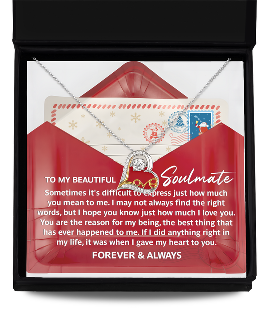 A Soulmate-Right Words - Love Dancing necklace, crafted in 14k gold, is elegantly displayed over a card with a heartfelt message inside an open red envelope.