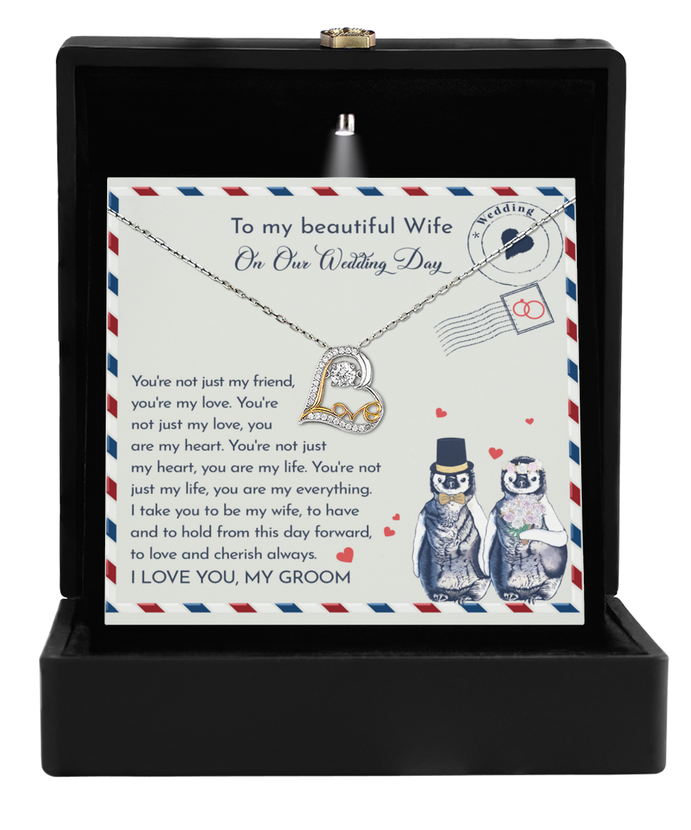 The "To Wife Wedding, Love And Cherish - Love Dancing Necklace" features a stunning 14k gold heart pendant and comes nestled in a sleek black box. Accompanied by a charming card adorned with penguins and a heartfelt message, it’s the perfect gift for your wife from her groom.