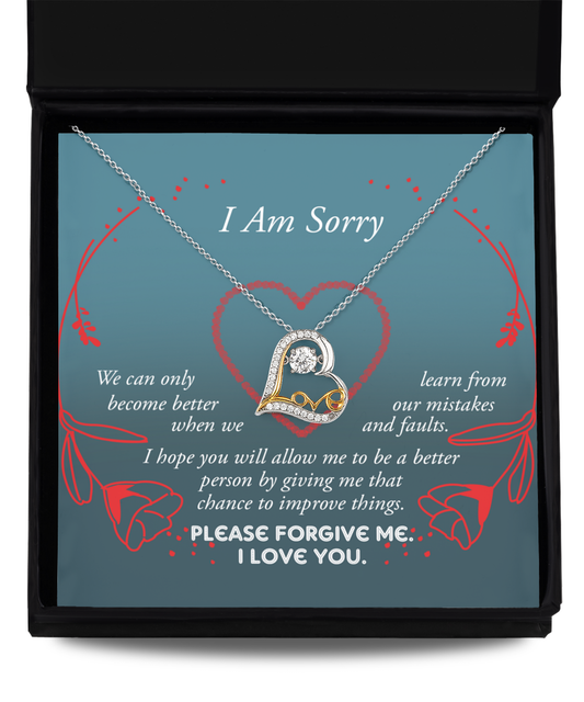 The "Sorry-Mistakes And Faults - Love Dancing Necklace" features an intertwined heart pendant, expertly crafted in .925 Sterling Silver. It is presented on a card reading "I Am Sorry," which includes a heartfelt apology message emphasizing growth and the pursuit of forgiveness, adorned with elegant red rose graphics.