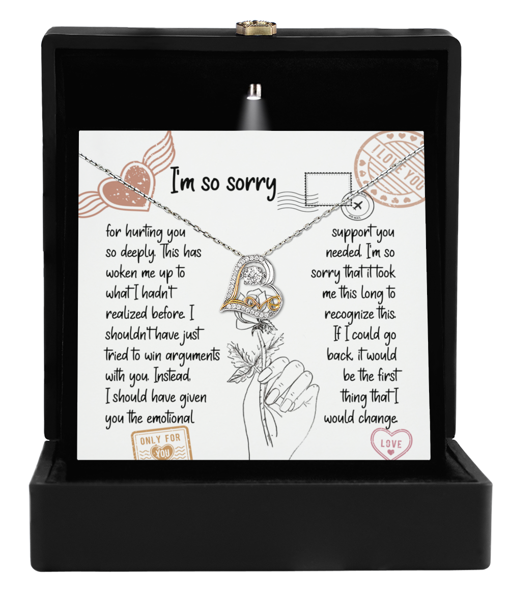 The Sorry-Emotional Support-Love Dancing Necklace, featuring a heart-shaped 14k gold pendant, comes in a sleek black box. An apology card with an illustration of a hand holding a rose elegantly completes the heartfelt gesture.