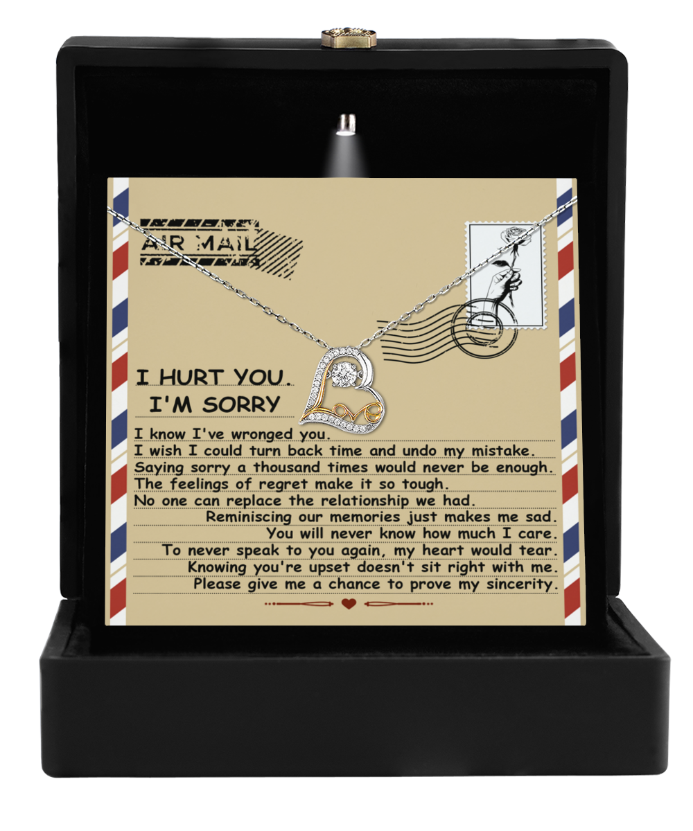 The Sorry-Makes Me Sad - Love Dancing Necklace features a heart-shaped pendant in 14k gold, packaged in a gift box with a vintage airmail-style apology card.