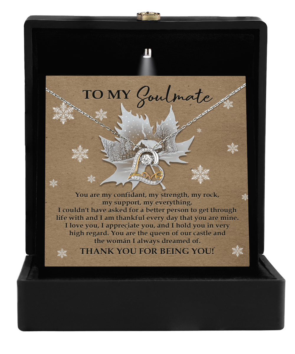 The Soulmate-Our Castle - Love Dancing Necklace, adorned with a heart pendant, is elegantly packaged in a box and comes with a heartfelt card conveying a soulmate message, set against a charming backdrop of maple leaves and snowflakes.