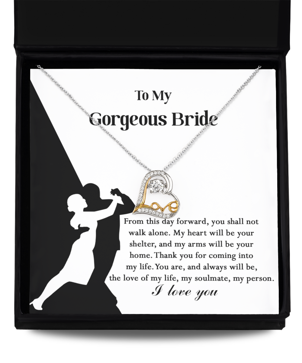 A Bride-Be Your Home - Love Dancing Necklace with a heart pendant, crafted in 14k gold plated, is displayed on a card featuring a silhouette of a dancing couple and a message addressing "My Gorgeous Bride," expressing love and commitment.