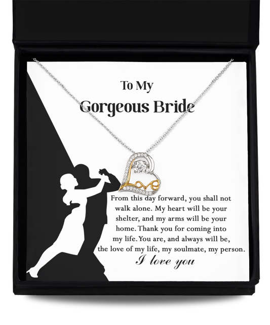 A Bride-Be Your Home - Love Dancing Necklace with a heart pendant, crafted in 14k gold plated, is displayed on a card featuring a silhouette of a dancing couple and a message addressing "My Gorgeous Bride," expressing love and commitment.