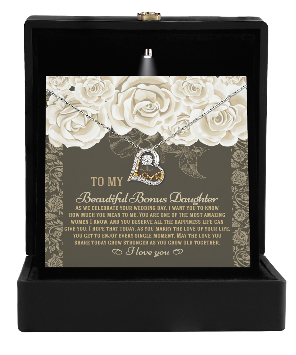 The To Bonus Daughter-Grow Old Together - Love Dancing Necklace, adorned with a heart pendant featuring the letter "A," is beautifully presented in a black box. Inside, you'll find a heartfelt message card, making it an ideal gift for your Bonus Daughter on her wedding day.