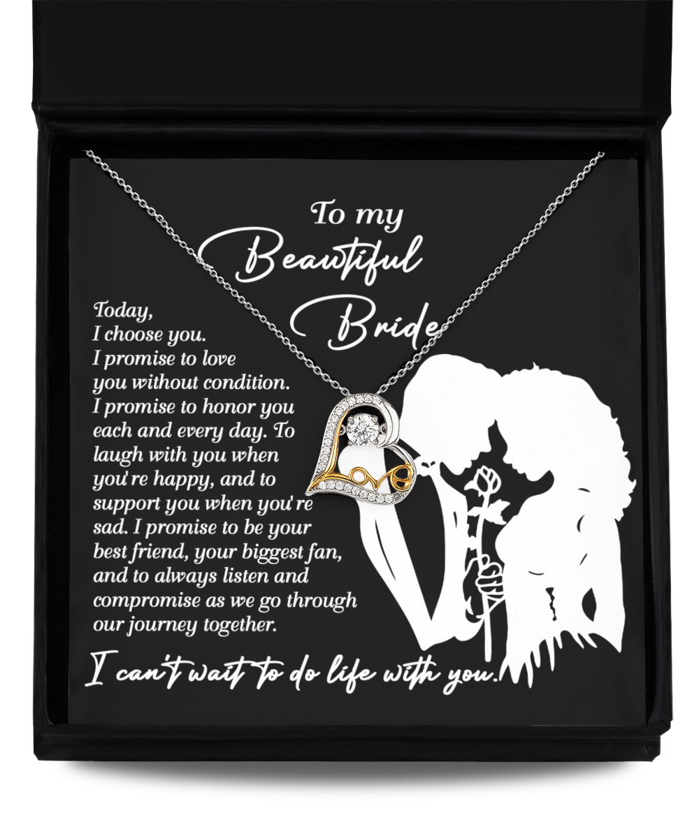 A Bride-I Choose You - Love Dancing Necklace featuring a heart and crystal pendant is displayed in a box. The lid showcases a silhouette of a couple, with text beginning "To my Beautiful Bride" followed by a romantic message. The pendant is available in Sterling Silver or 14k gold for an elegant touch.