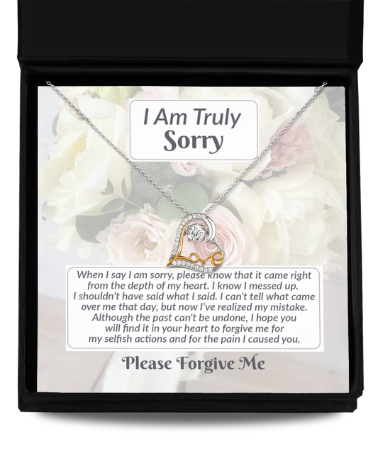 A 14k gold "Sorry-What I Said - Love Dancing Necklace" with a heart pendant, presented in a gift box accompanied by an apology note that expresses regret and asks for forgiveness for causing pain.