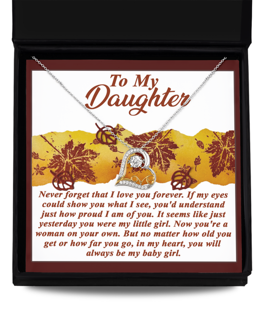 The Daughter-On Your Own - Love Dancing Necklace, featuring a heart pendant adorned with shimmering Cubic Zirconia and 14k Gold, is elegantly displayed in a box. The lid features a heartfelt message addressed to a daughter.