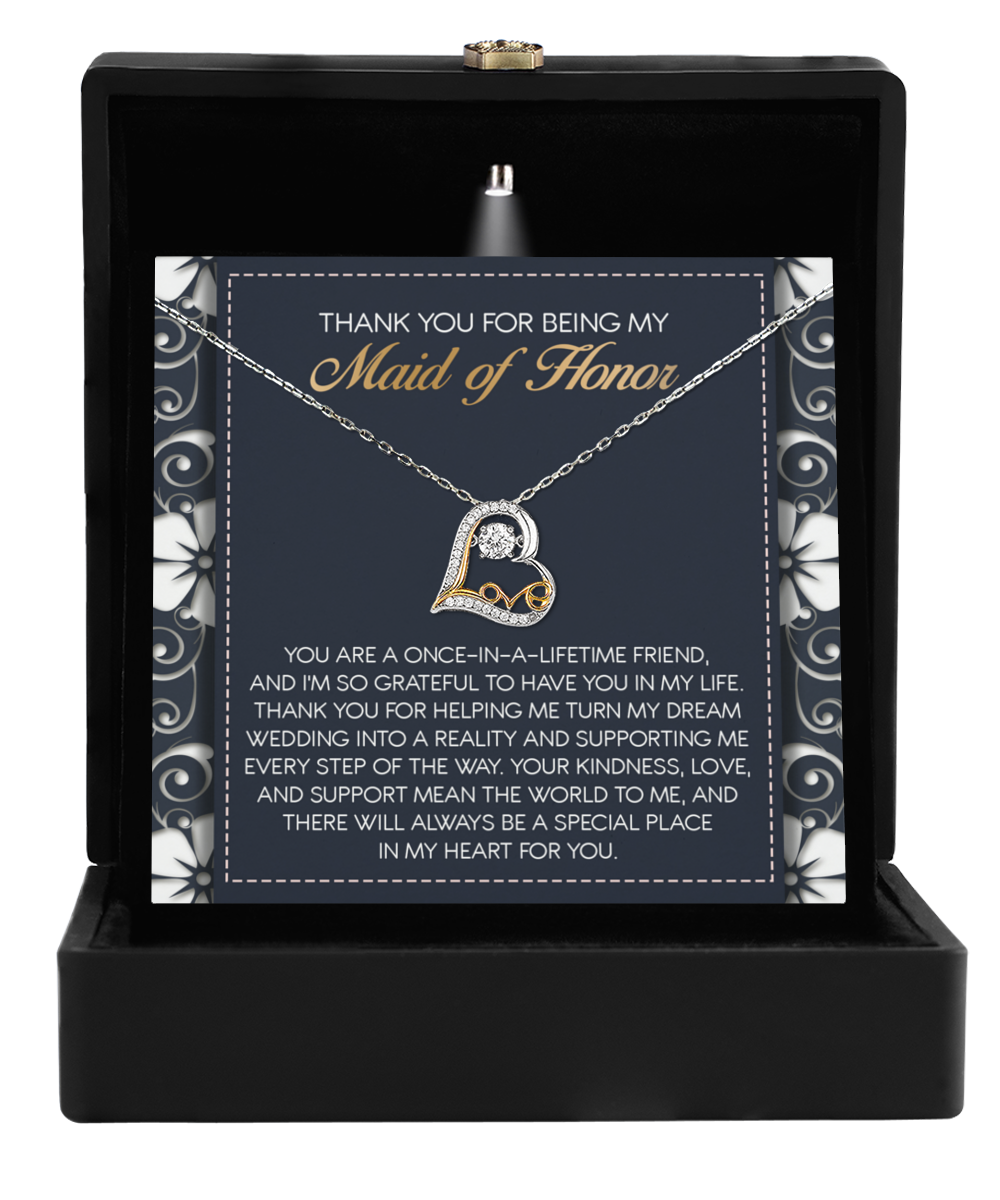 The "To Maid of Honor-World To Me - Love Dancing Necklace," heart-shaped and inscribed with a message of appreciation, is elegantly showcased in an open black box—making it the perfect gift for the Maid of Honor.