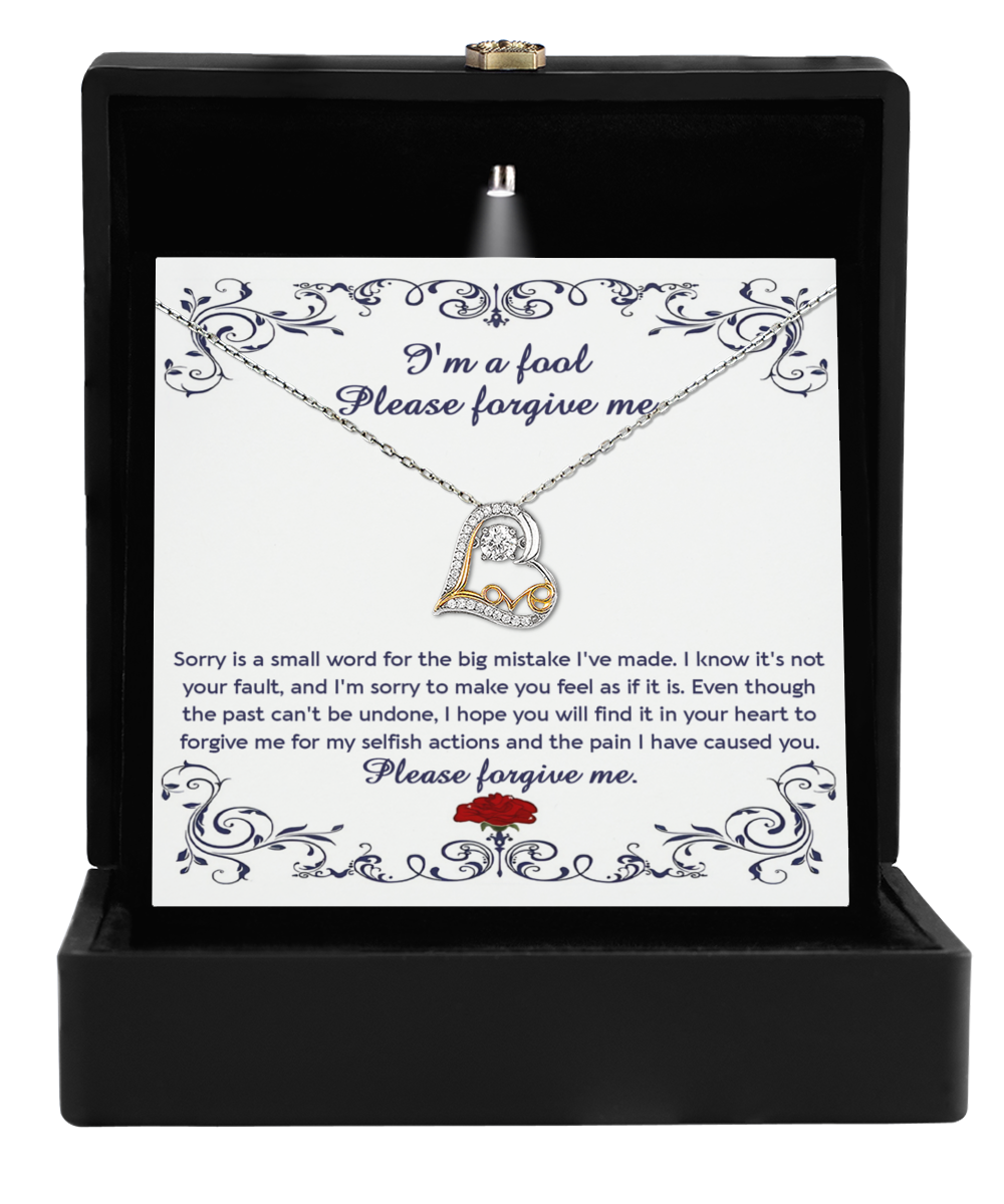 An open black jewelry box unveils the Sorry-I_m A Fool - Love Dancing Necklace in 14k gold, with a heartfelt note apologizing for past mistakes and seeking forgiveness—a symbol of rekindling connections through maternal love's warmth.