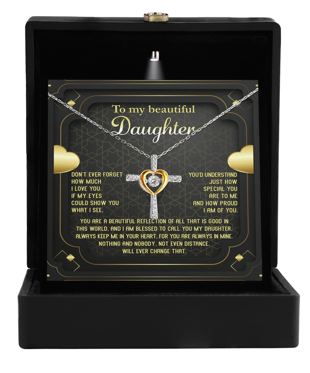 A black jewelry box with an illuminated lid showcases the "To Daughter-Beautiful Reflection - Cross Dancing Necklace," crafted from .925 Sterling Silver and featuring a heart at its center. Inside, a heartfelt message reads, "To my beautiful daughter," expressing love and pride.