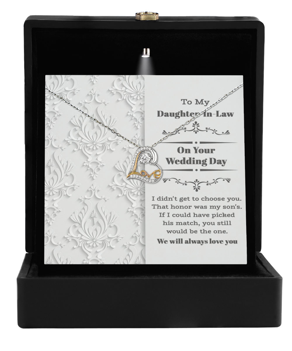 The Daughter-In-Law Wedding - Be The One Love Dancing Necklace, featuring a heart pendant, is displayed beautifully in an open black box with a heartfelt message. This necklace makes an ideal gift to celebrate the unique bond with your daughter-in-law on her special wedding day.