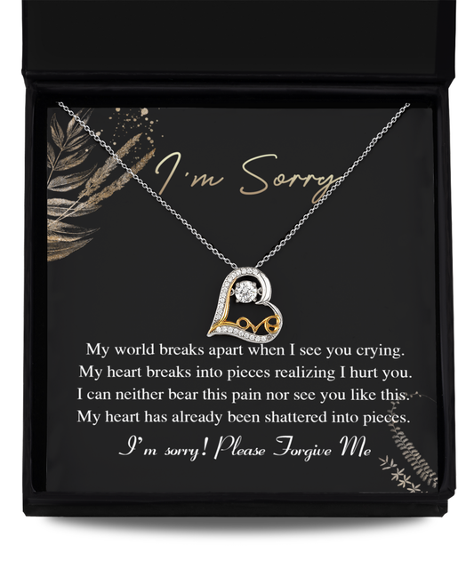 The Sorry-See You Crying - Love Dancing Necklace is a 14k gold triple-plated necklace featuring a heart-shaped pendant, elegantly displayed in an open gift box. The inner lid of the box reads, "I'm Sorry," accompanied by an apologetic message beneath.