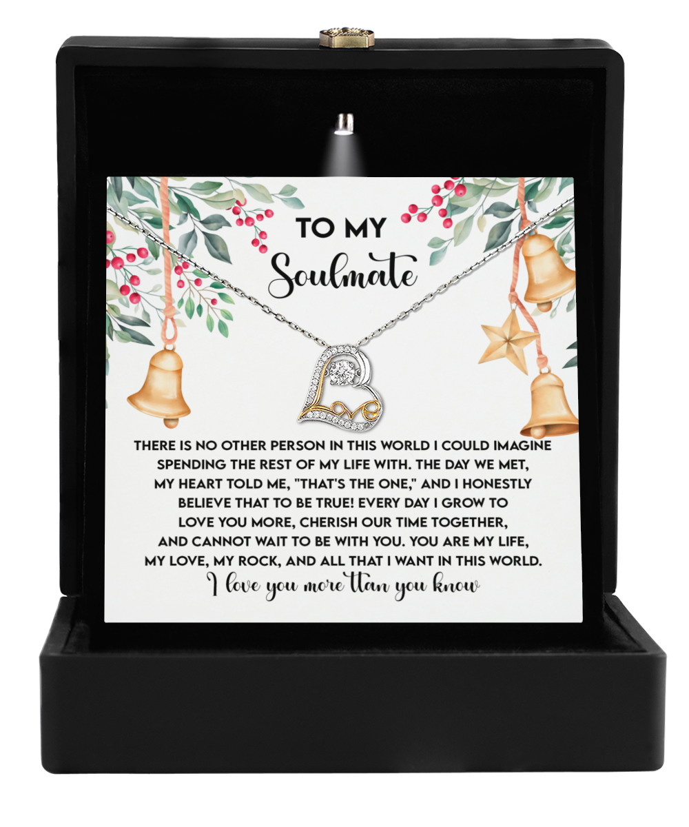 A gift box featuring the Soulmate-Be With You - Love Dancing Necklace, showcasing a heart-shaped pendant crafted in .925 Sterling Silver, accompanied by a message card titled "To My Soulmate," adorned with holiday-themed illustrations.