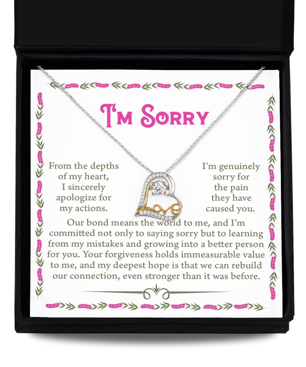 The "Sorry-A Better Person - Love Dancing Necklace," a .925 Sterling Silver creation with a heart-shaped pendant, lies on an open box featuring a heartfelt message apologizing for past mistakes and expressing hope for rebuilding a connection, all surrounded by elegant floral borders.