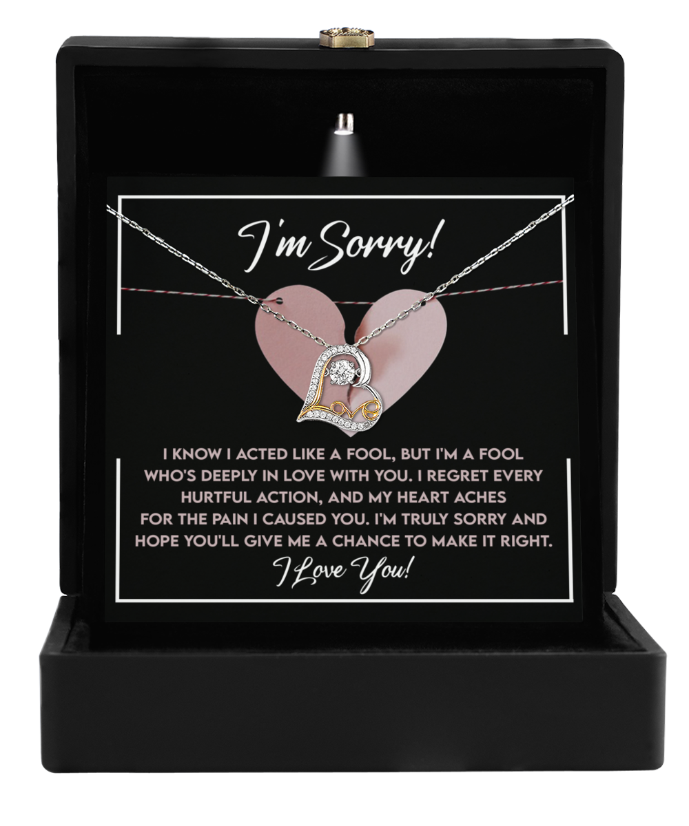 A Sorry-Deeply In Love - Love Dancing Necklace, crafted in 14k gold, is displayed in a black case with a note that reads "I'm Sorry!" and includes a heartfelt apology text.