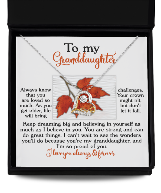 A heart-shaped Love Dancing Necklace, titled "Granddaughter-Do Great Things," crafted in 14k Gold or Sterling Silver, is paired with a heartfelt message to a granddaughter about love, strength, and dreams, beautifully set against a backdrop of autumn leaves.