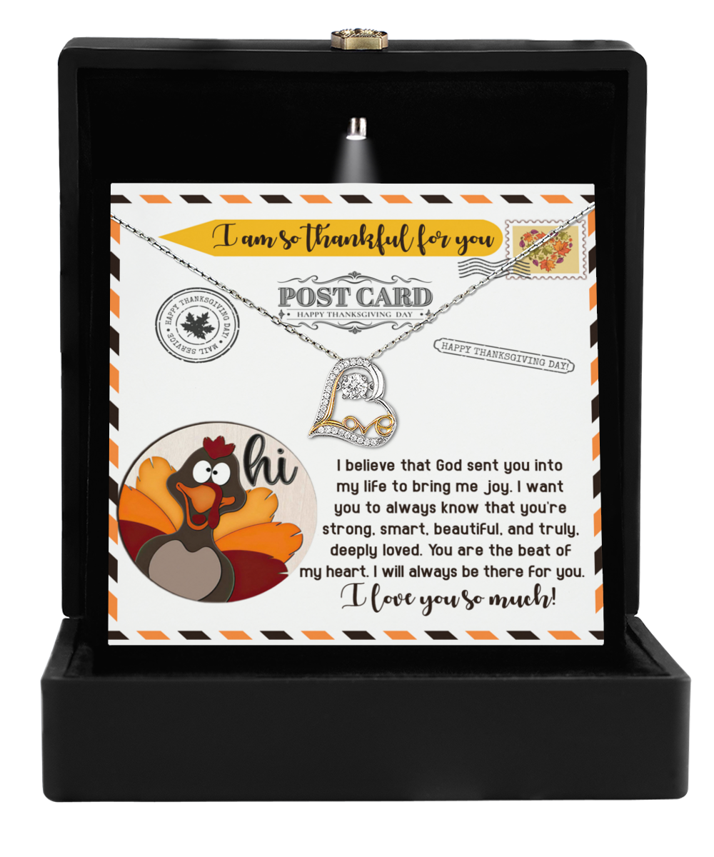 A jewelry box featuring a Thanksgiving-The Beat Love Dancing Necklace, complete with a card adorned with a cartoon turkey and expressing a heartfelt message of gratitude and love.