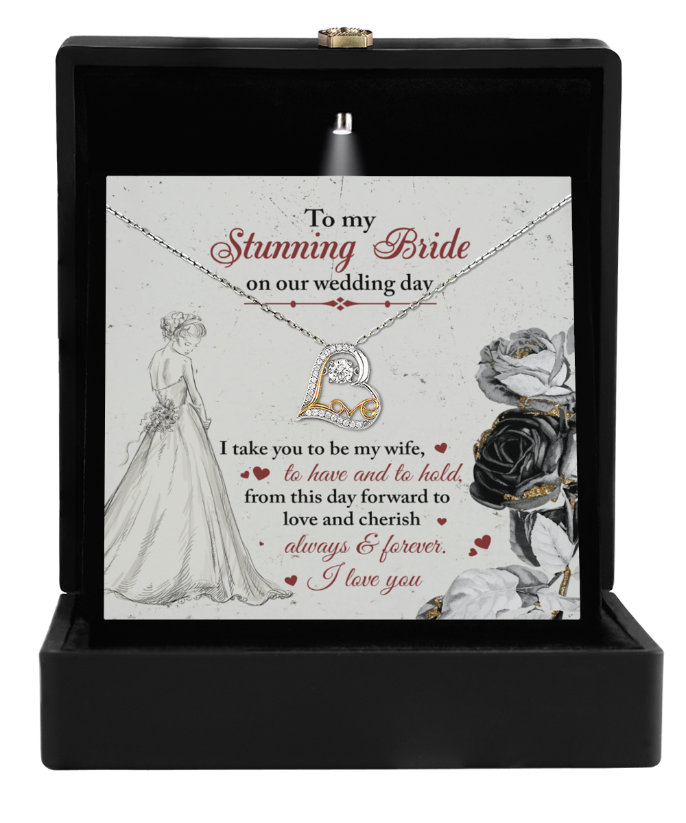 Open the jewelry box to reveal the Bride-Be My Wife - Love Dancing Necklace, featuring a sparkling heart pendant. The background card is adorned with floral and bridal illustrations and conveys a romantic message to the bride on her wedding day, making it the perfect gift.