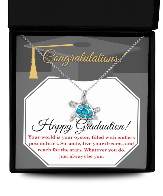 Sentence with product name: A graduation-themed Happy Graduation, Your World Is Your Oyster - Opal Turtle Necklace in a gift box with the message "congratulations, happy graduation!" and inspirational text about possibilities and dreams.