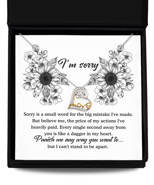 The Sorry-Small Word - Love Dancing Necklace, a silver chain adorned with a gold and silver heart pendant featuring small gemstones, is elegantly displayed on a black box lid. Surrounding the necklace are illustrated sunflowers and a heartfelt apology message in refined 14k gold script, expressing regret for a mistake and seeking forgiveness.