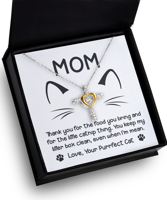 A pendant necklace in a box with a message for mom from a "To Cat Mom, When I'm Mean - Cross Dancing Necklace" thanking her for care, featuring a heart-shaped charm and cat whiskers design—now crafted as a 14k gold