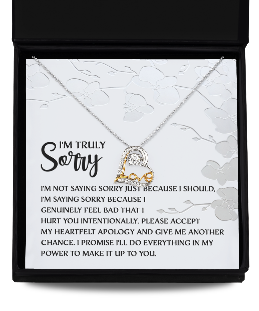 The Sorry-Feel Bad - Love Dancing Necklace is displayed in an open gift box with an apology message inside. Perfect for expressing heartfelt sentiments, this heart-shaped pendant necklace is crafted from sterling silver, ensuring timeless elegance.