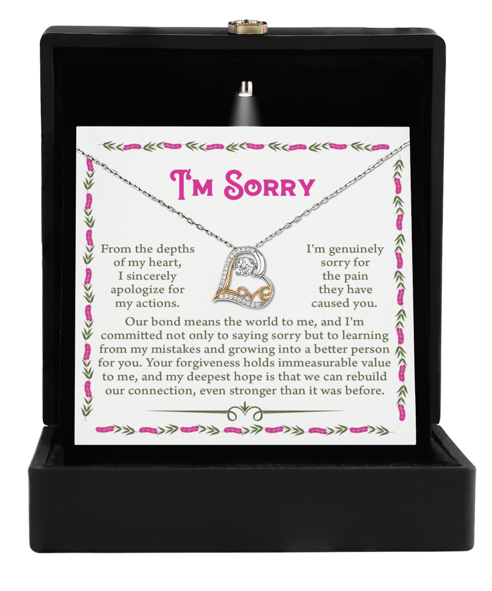 Inside an open black box rests the "Sorry-A Better Person - Love Dancing Necklace," a silver heart-shaped piece crafted from .925 Sterling Silver. The box features a card with the words, "I'm sorry," accompanied by a heartfelt apology message.