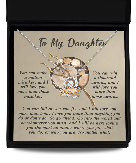 Inside a black box, the Daughter-A Thousand Awards - Love Dancing Necklace sparkles brilliantly. This heart-shaped sterling silver necklace is adorned with cubic zirconia and rests on a card featuring an inspirational message for your daughter, symbolizing cherished affection and encouragement.