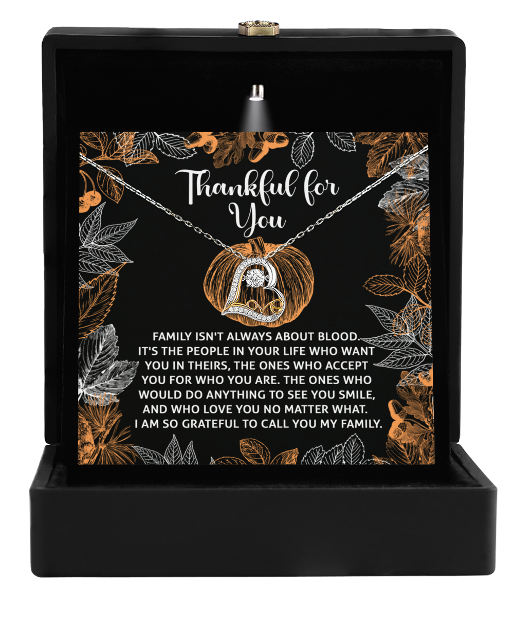 The Thanksgiving-To Call You - Love Dancing Necklace, featuring a ring pendant, is beautifully presented in a black box. It is accompanied by a card that conveys family and gratitude, adorned with an orange and white floral design. Available in either sterling silver or 14k gold, this necklace serves as the ideal symbol of connection and appreciation.