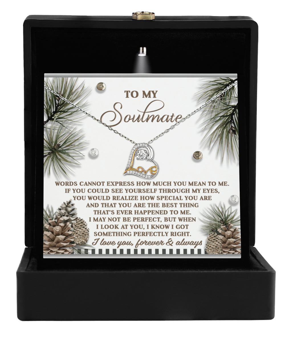 The Soulmate-Perfectly Right - Love Dancing Necklace, featuring a heart and infinity pendant crafted in sterling silver, is elegantly presented in a black jewelry box. It includes a romantic message card addressed to "Soulmate," adorned with charming pine cone and leaf designs.