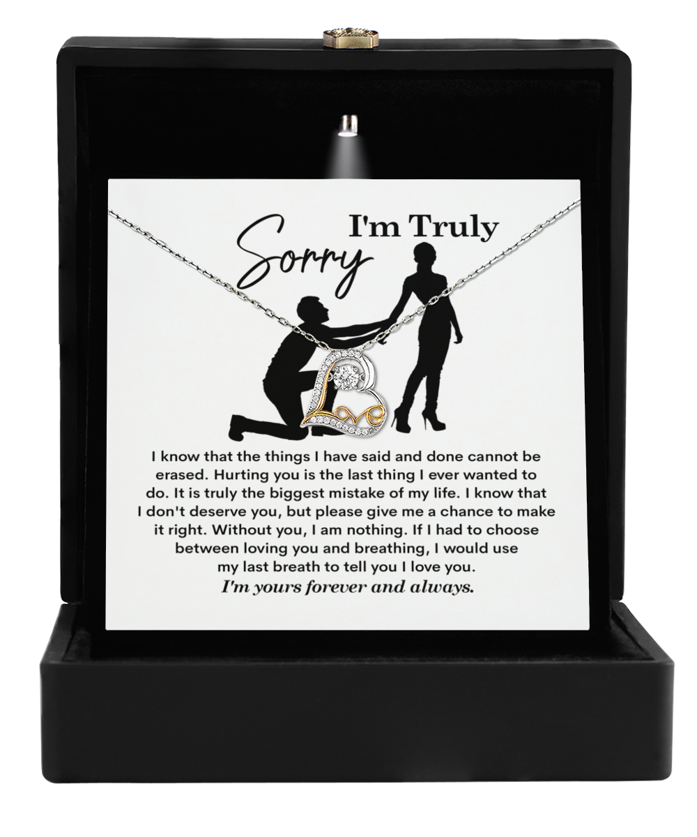 The Sorry-My Last Breath - Love Dancing Necklace, a 14k gold piece with a heart-shaped pendant, is presented in an open box and comes with a card saying "I'm Truly Sorry," conveying heartfelt remorse and affection about love and mistakes.