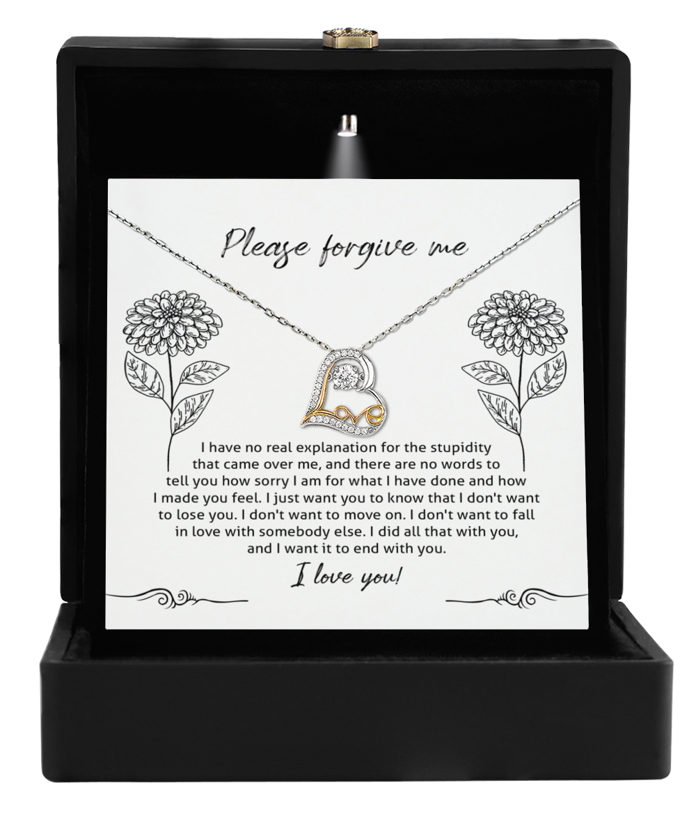 The Sorry-Real Explanation - Love Dancing Necklace features a heart-shaped pendant crafted in 14k gold, displayed on an apology message card and nestled in a sleek black box.