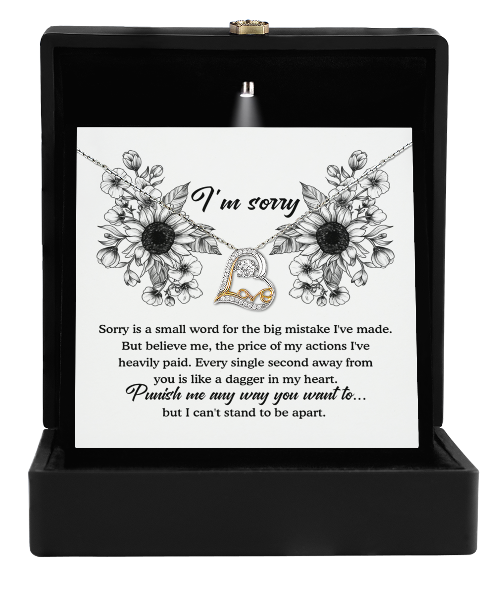 A "Sorry-Small Word" jewelry box with a luxurious black velvet interior showcases an exquisite Love Dancing Necklace, adorned with sparkling cubic zirconia. The heartfelt apology message, embellished with delicate floral illustrations, reads: "I'm sorry. Punish me any way you want to... but I can't stand to be apart.