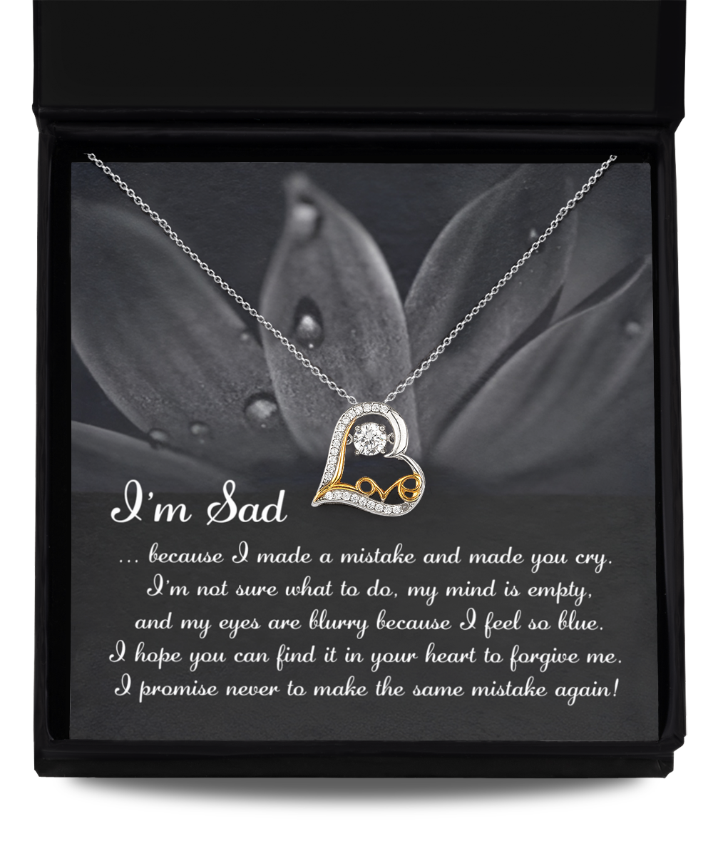 The "Sorry-Feel So Blue - Love Dancing Necklace," a heart-shaped pendant crafted with genuine .925 Sterling Silver and AAAA Cubic Zirconia, is displayed in an open box with a message that reads: "I'm Sad...because I made a mistake and made you cry... I promise never to make the same mistake again.