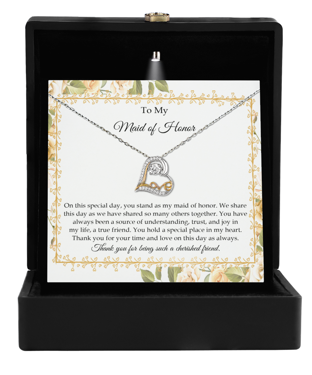 The To Maid of Honor-Share This Day - Love Dancing Necklace, beautifully crafted in 14k gold, graces an open black box. Complementing it is a heartfelt card addressed to "My Maid of Honor" with a touching thank you message.