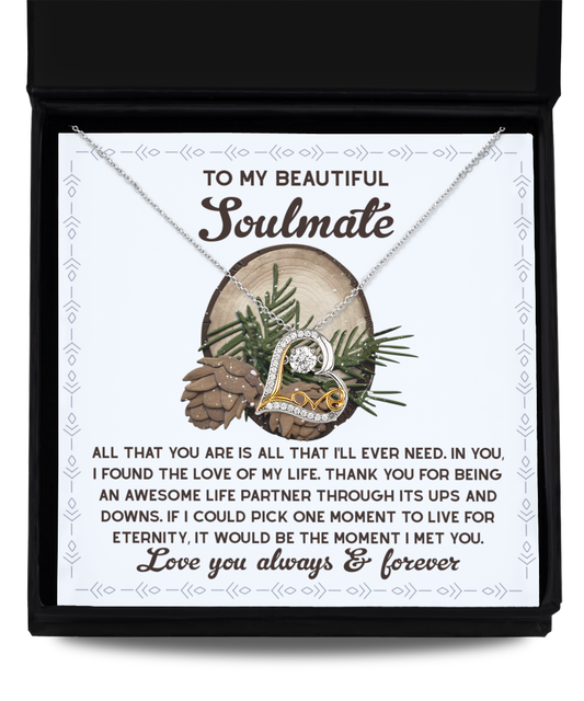 The Soulmate-One Moment - Love Dancing Necklace, a sterling silver piece with a heart pendant, is presented in a box decorated with pinecone illustrations and includes a touching message about finding a soulmate.