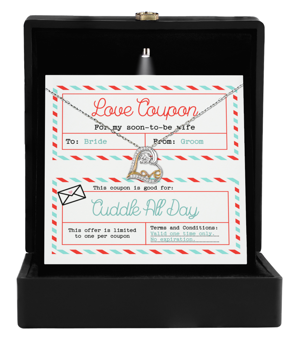 The To Wife Wedding-Love Coupon - Love Dancing Necklace, featuring a heart-shaped pendant, shines in a black box alongside a printed love coupon from the groom to his bride, offering a day of cuddles as the perfect gift.