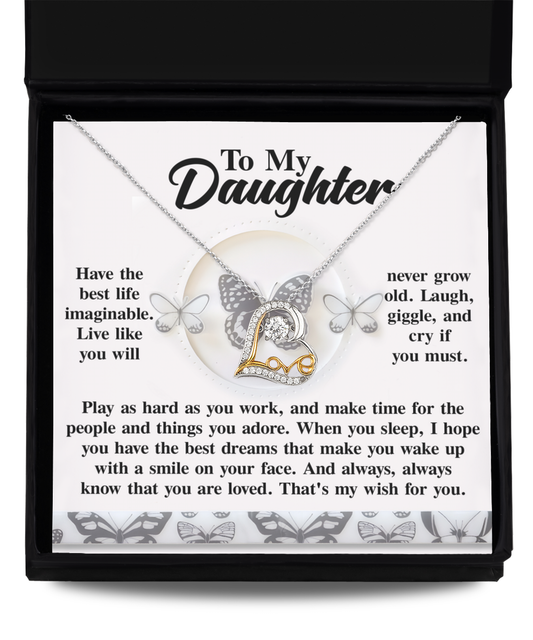 The Daughter-My Wish - Love Dancing Necklace, with its heart-shaped pendant and rhodium plating for a brilliant shine, is elegantly displayed on a chain in a box featuring a touching message addressed "To My Daughter.