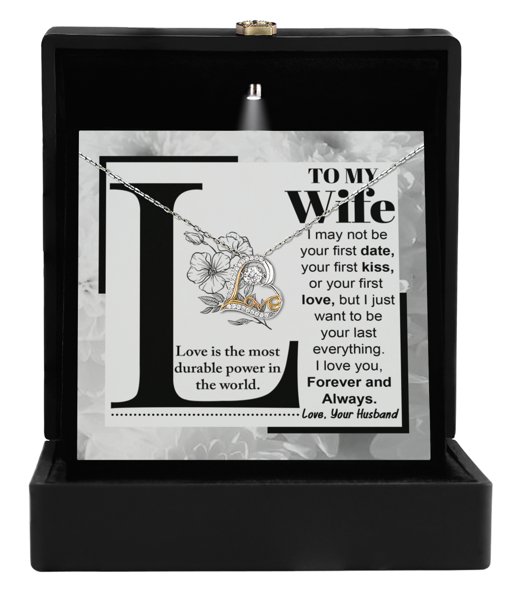 The "To Wife, Love Is - Love Dancing Necklace" comes in a black box and features a stunning heart-shaped pendant crafted from 14k gold. It elegantly showcases the heartfelt message, "To My Wife," along with tender expressions of love from a husband.